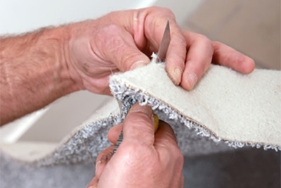 man cutting carpet